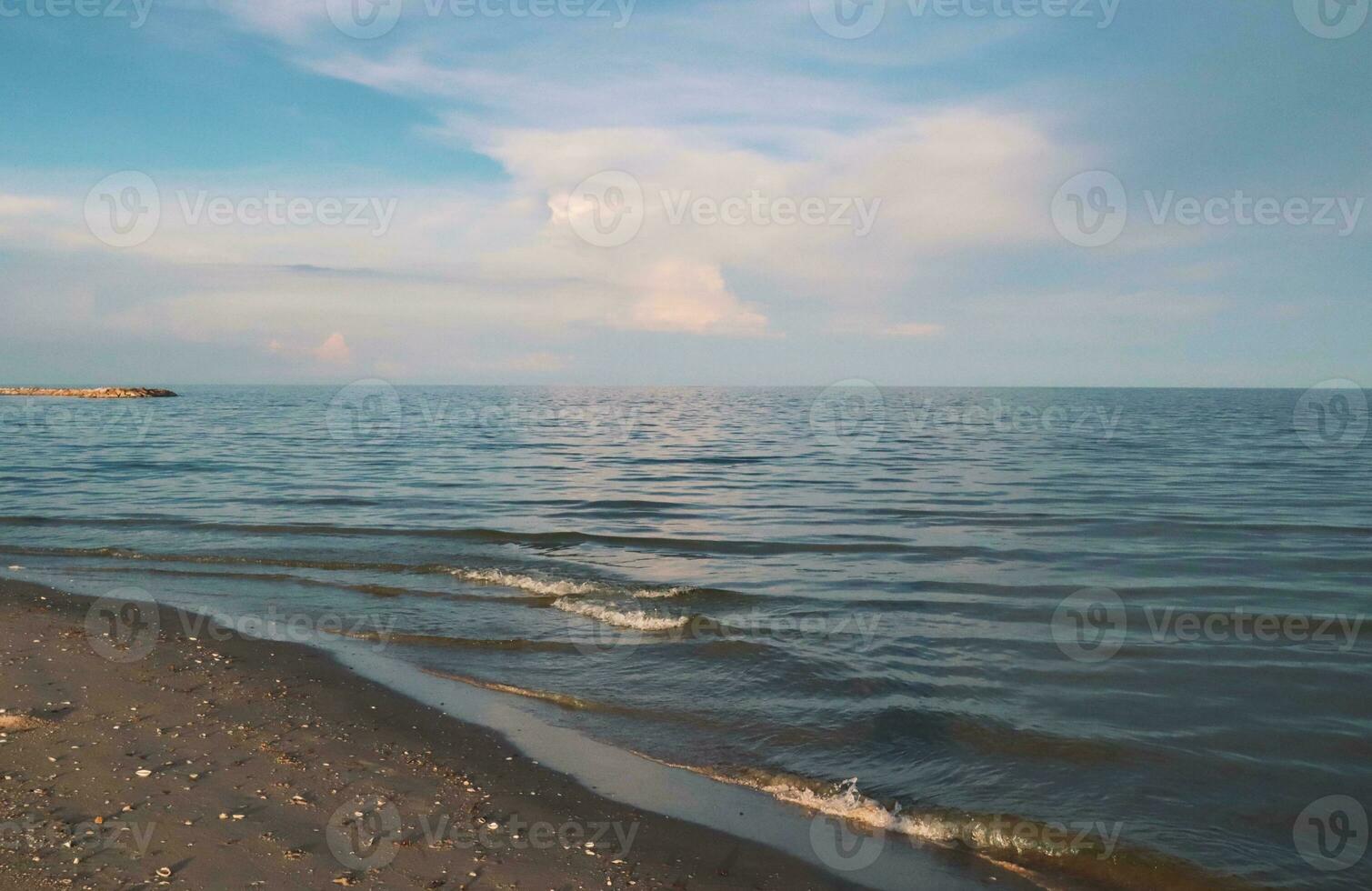 landskap av hav och strand under solnedgång natt tid med vanilj himmel foto