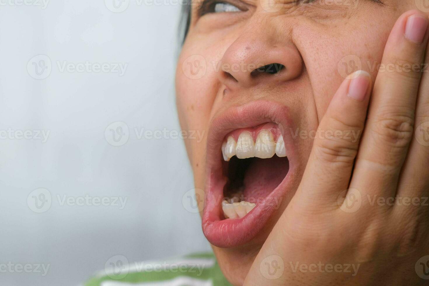 asiatisk kvinna innehav henne hand på henne kind känsla tandvärk, tand förfall, gingivit eller dålig andetag problem. tandvärk och oral hälsa begrepp. foto