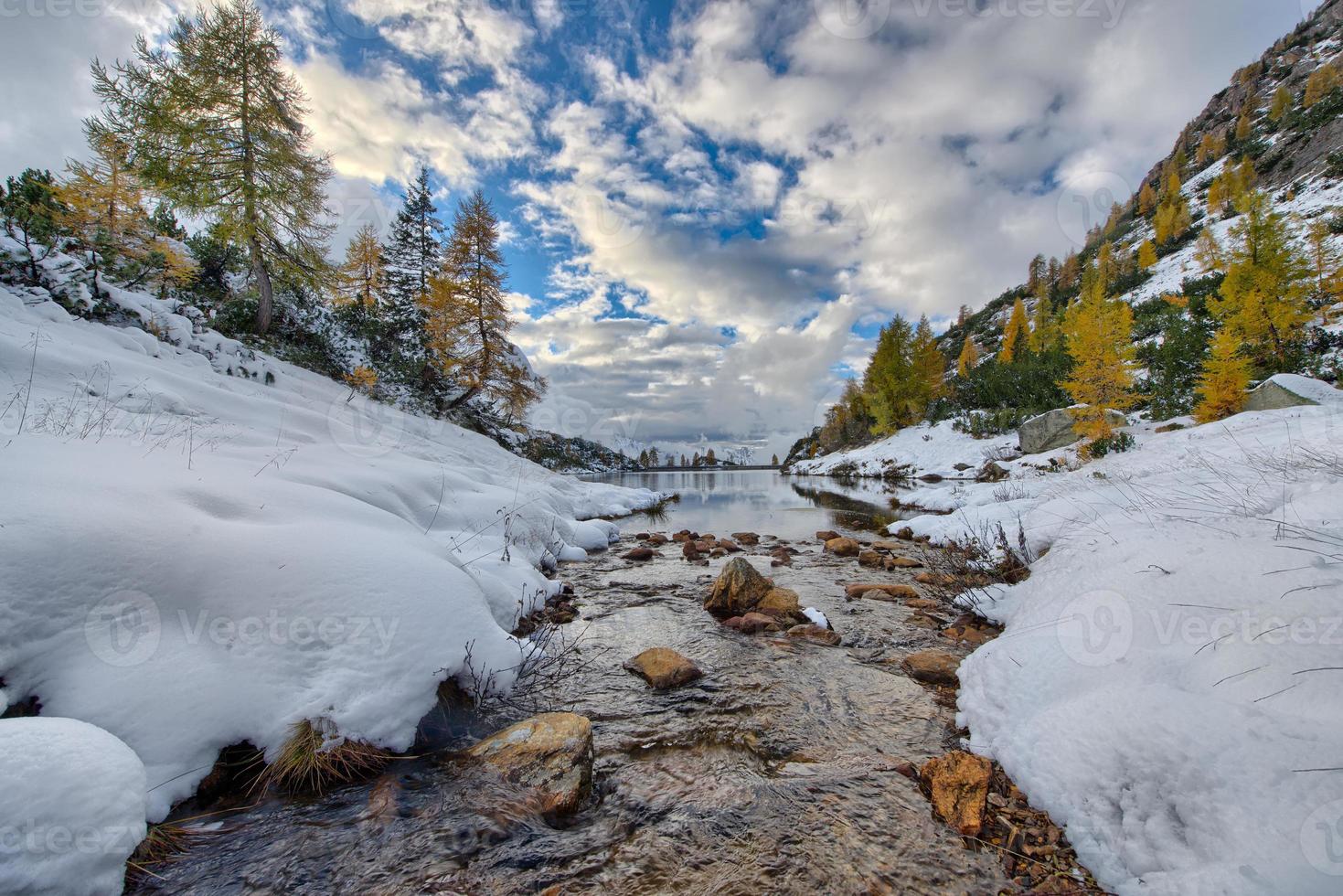 berg liten flod kommer in i sjön foto