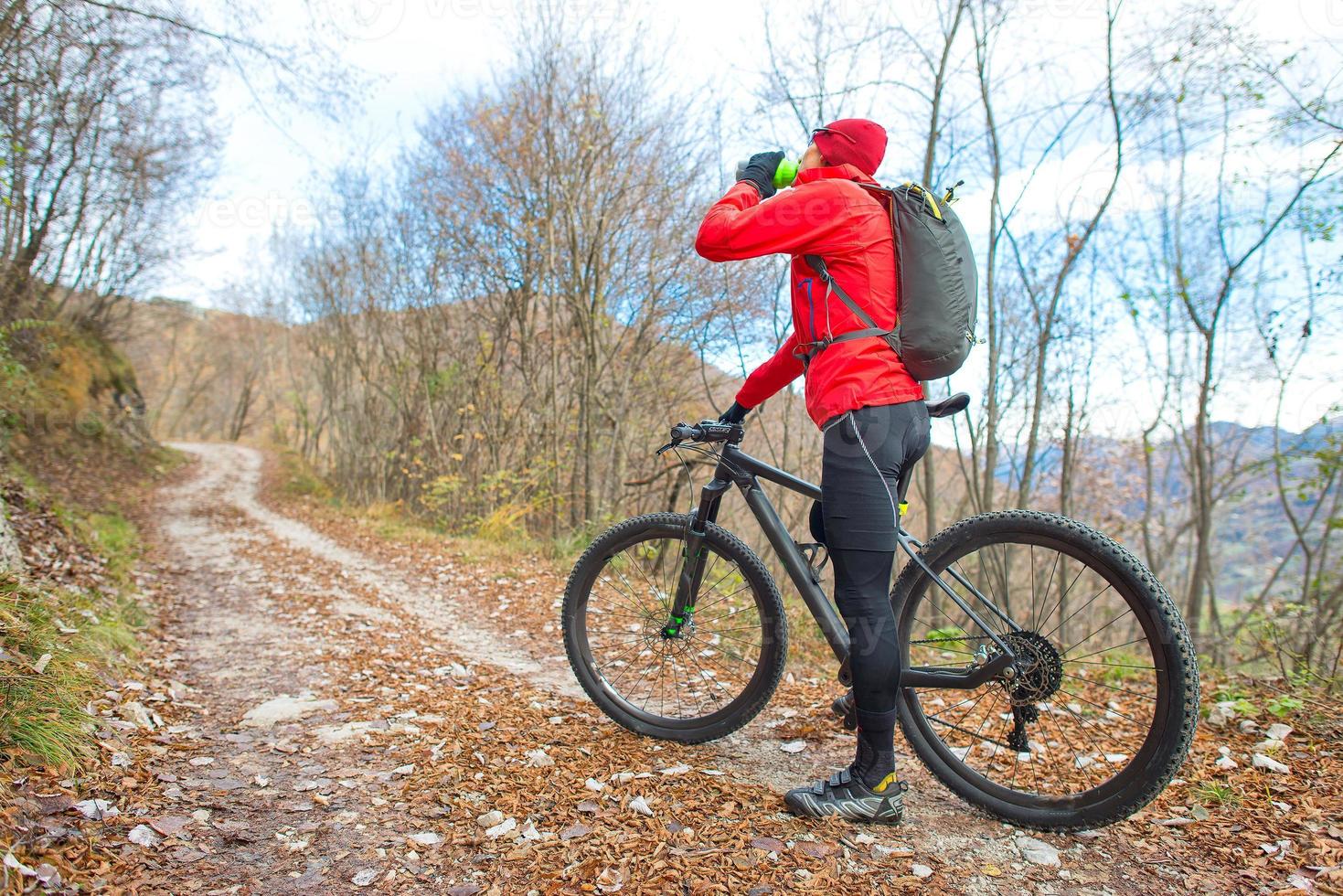 man mountainbike vilar och dricker från matsalen foto