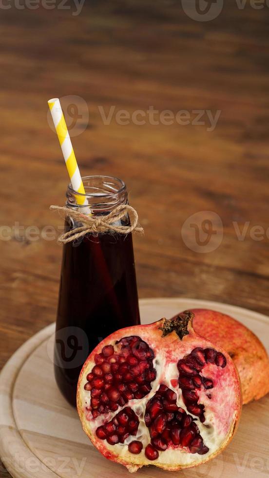 mogna granatäpplen med juice på träbakgrund. foto