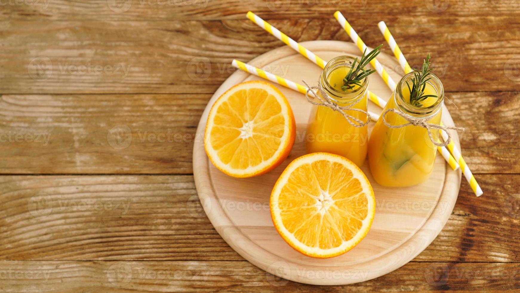 apelsinjuice i glasflaskor. saften är dekorerad foto