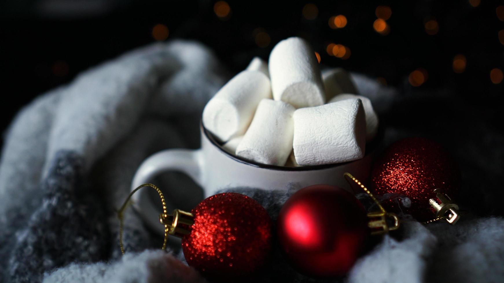 mugg varm choklad med marshmallow på en mörk bakgrund foto