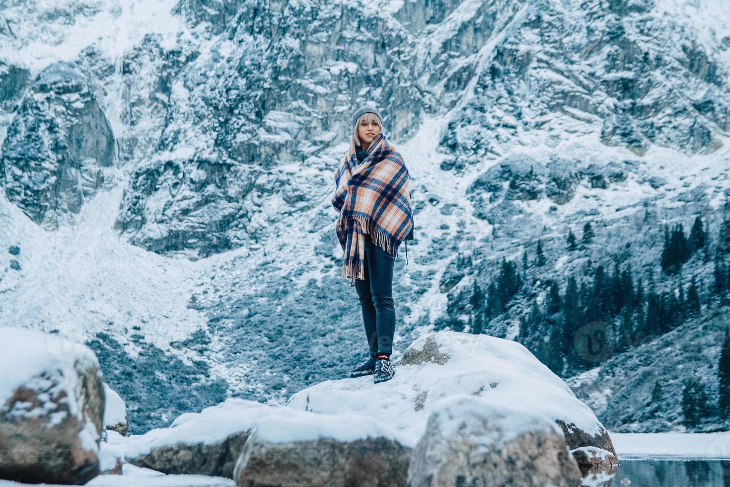 kvinna i en poncho i bergen på vintern, äventyr och resor foto