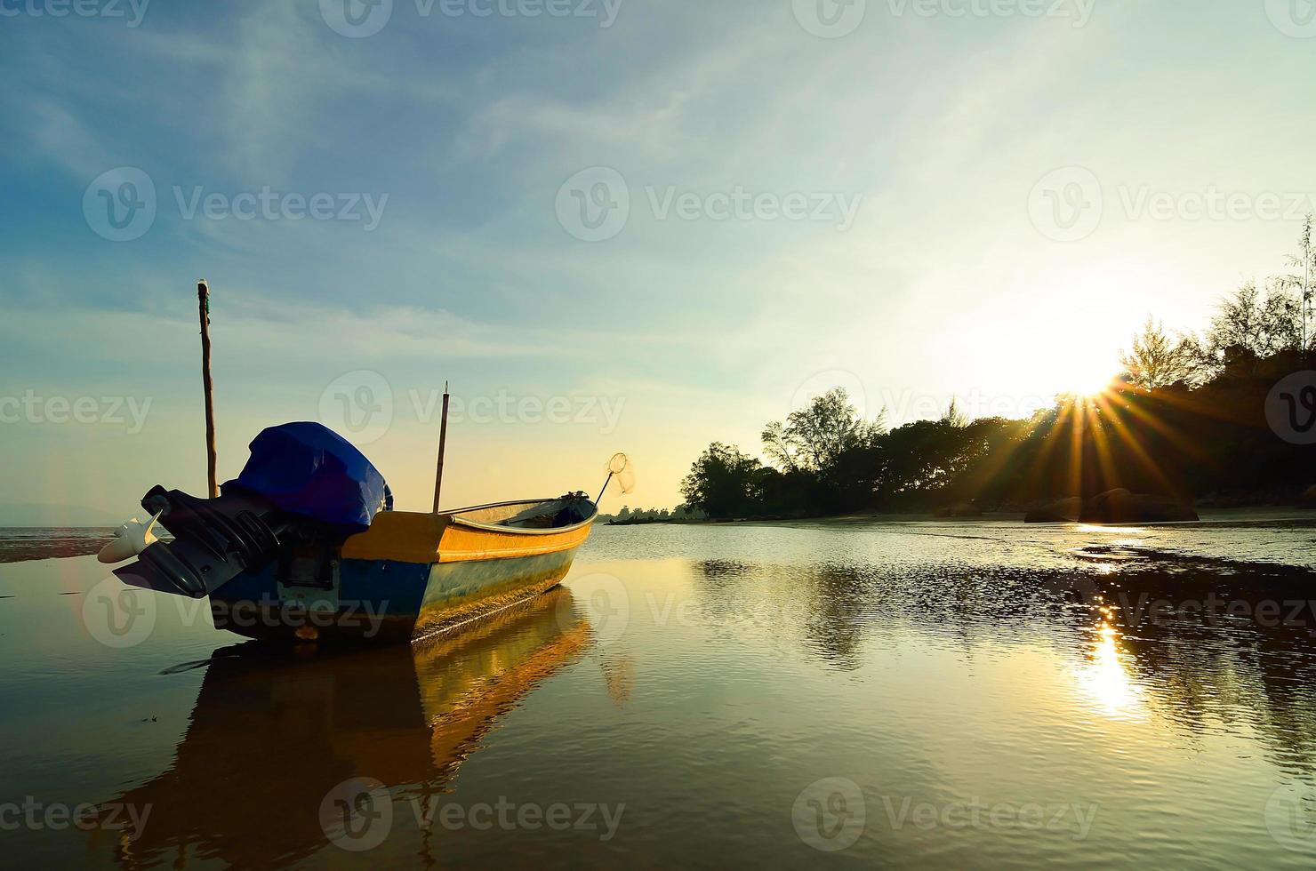 båt nära stranden när solen går ner foto