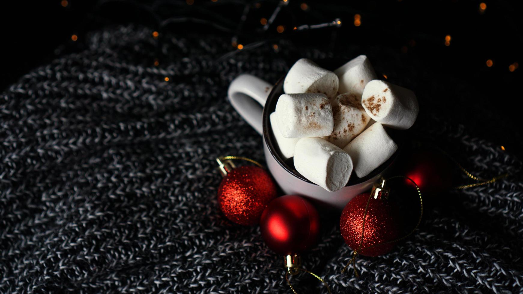 mugg varm choklad med marshmallow på en mörk bakgrund foto