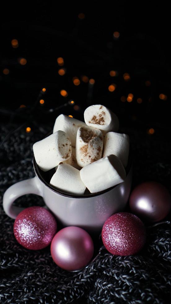 varm varm choklad med marshmallows på ett bord med lampor bokeh foto