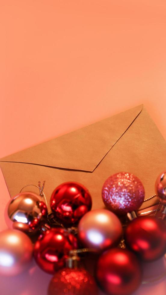 kuvert från hantverkspapper med julröda och rosa bollar på rosa foto
