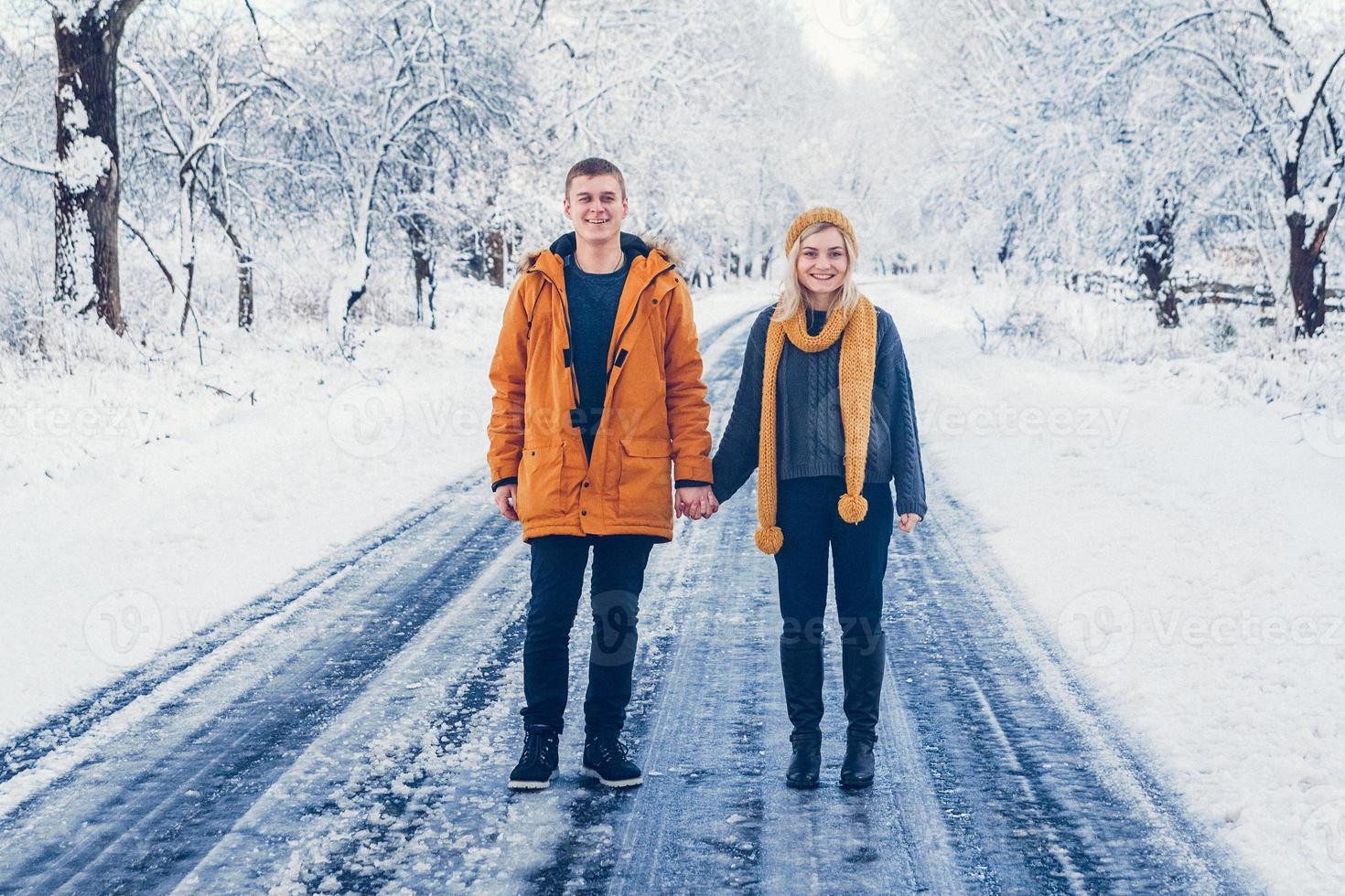 kille och tjej går och har kul i skogen på vintern foto