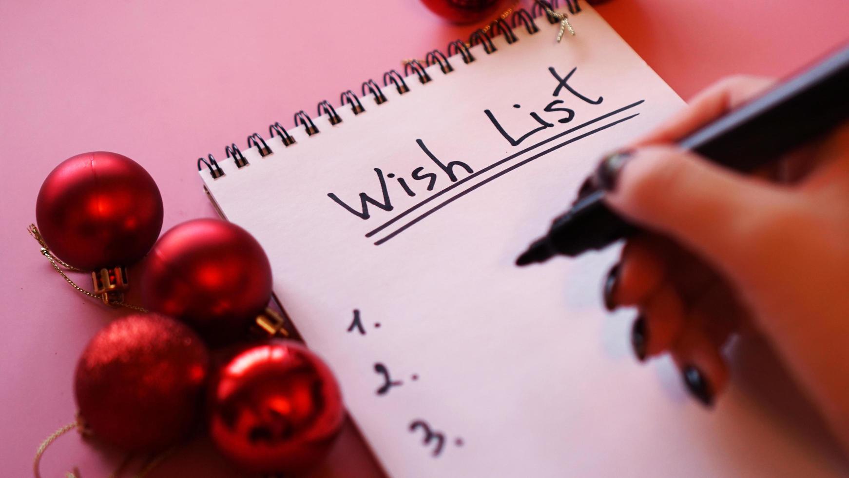 kvinna skriver sin önskelista. festlig design på rosa bakgrund foto