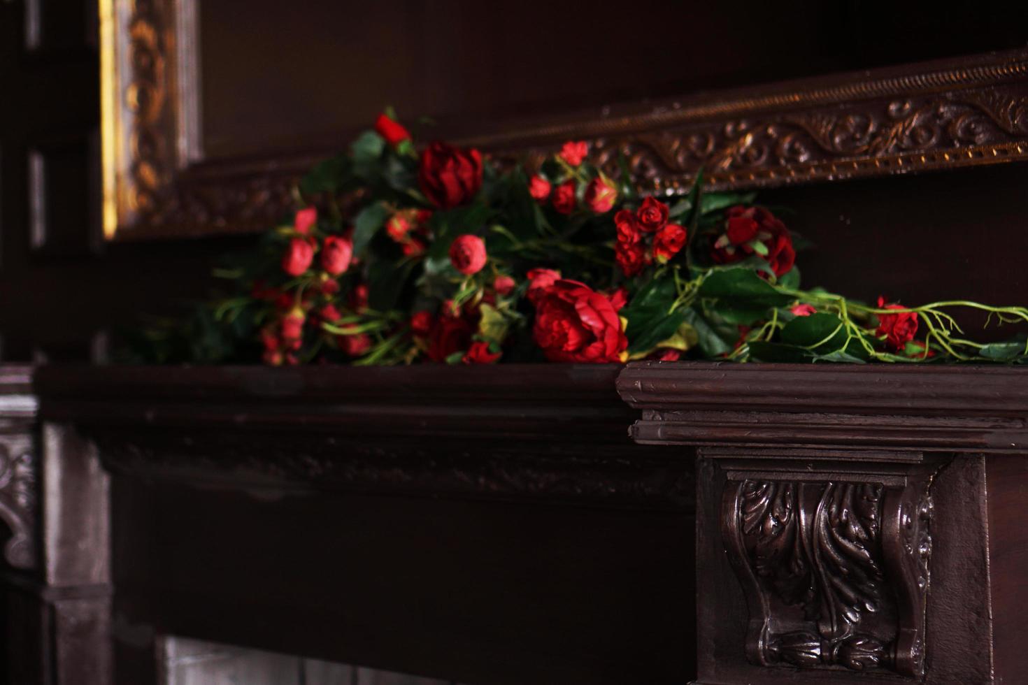 ett falskt blomsterarrangemang på en öppen spismantel foto