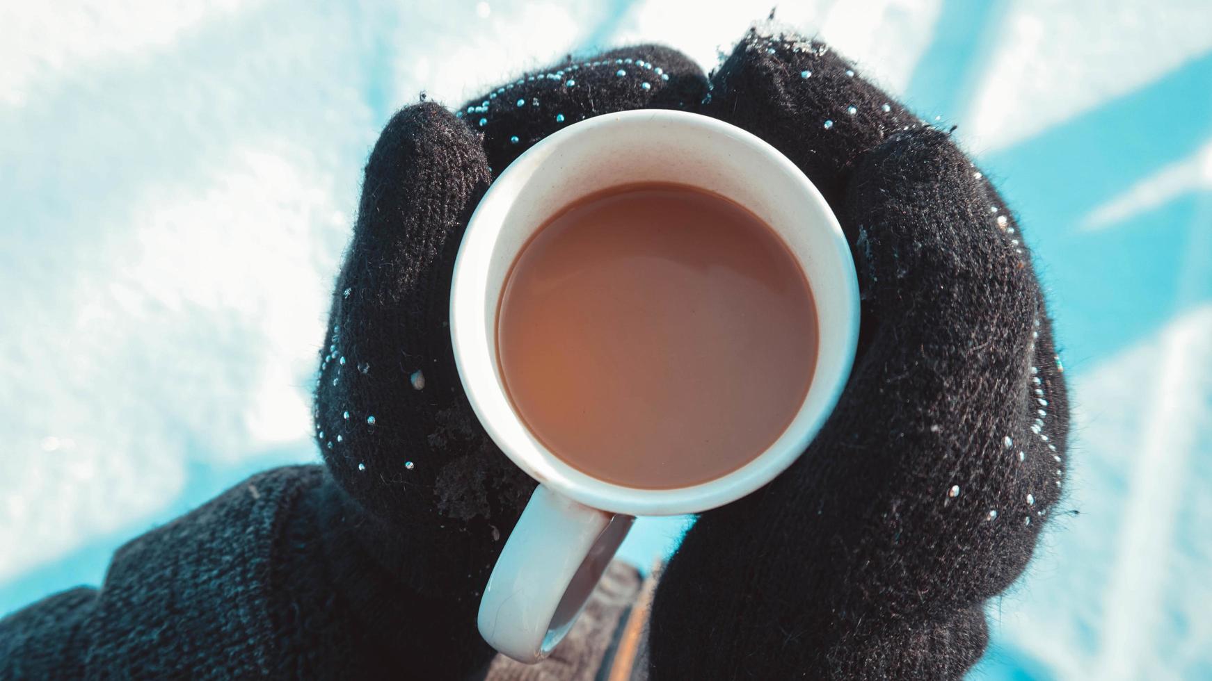 varm kopp varmt kaffe som värmer i händerna på en tjej foto