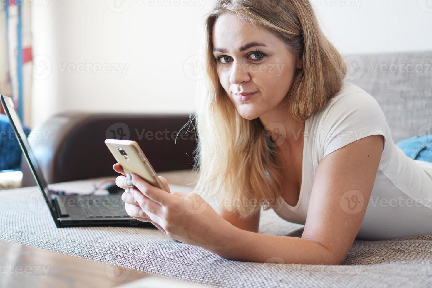 attraktiv ung kvinna som kopplar av på en soffa hemma foto