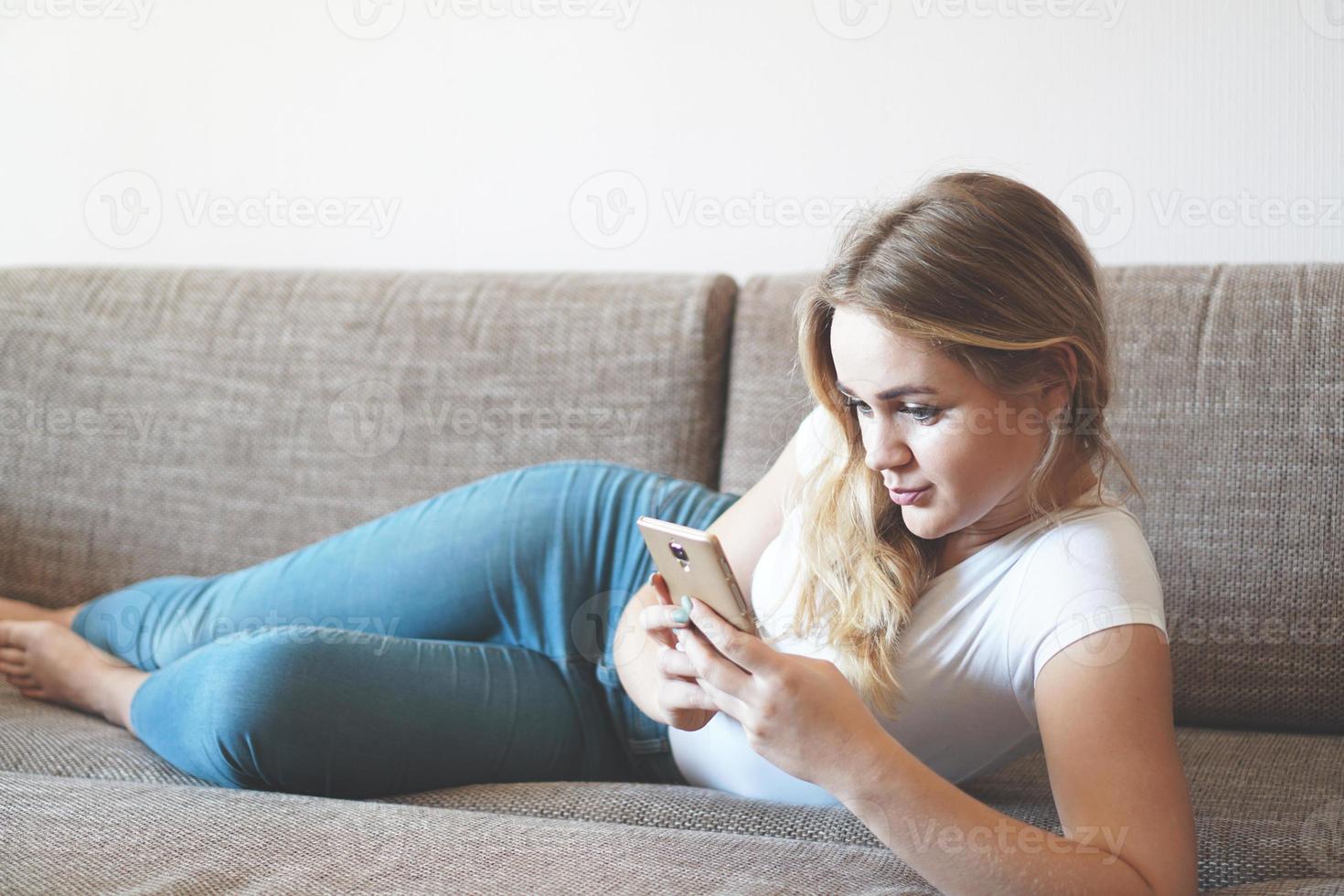 attraktiv ung kvinna som kopplar av på en soffa hemma foto
