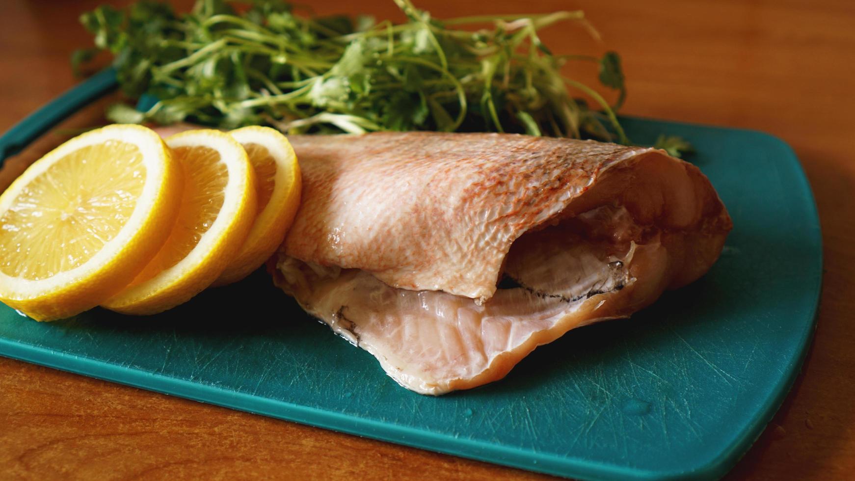 färsk fisk, rå torskfiléer med tillsats av örter och citron foto