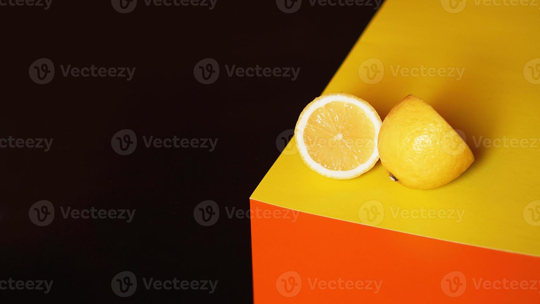 färsk gul citron på svart och orange bakgrund foto