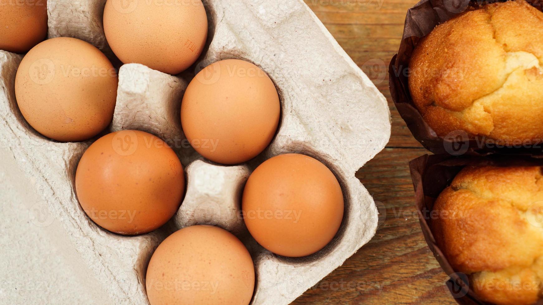 en bricka med ägg och färska läckra muffins i pappersformar på trä foto