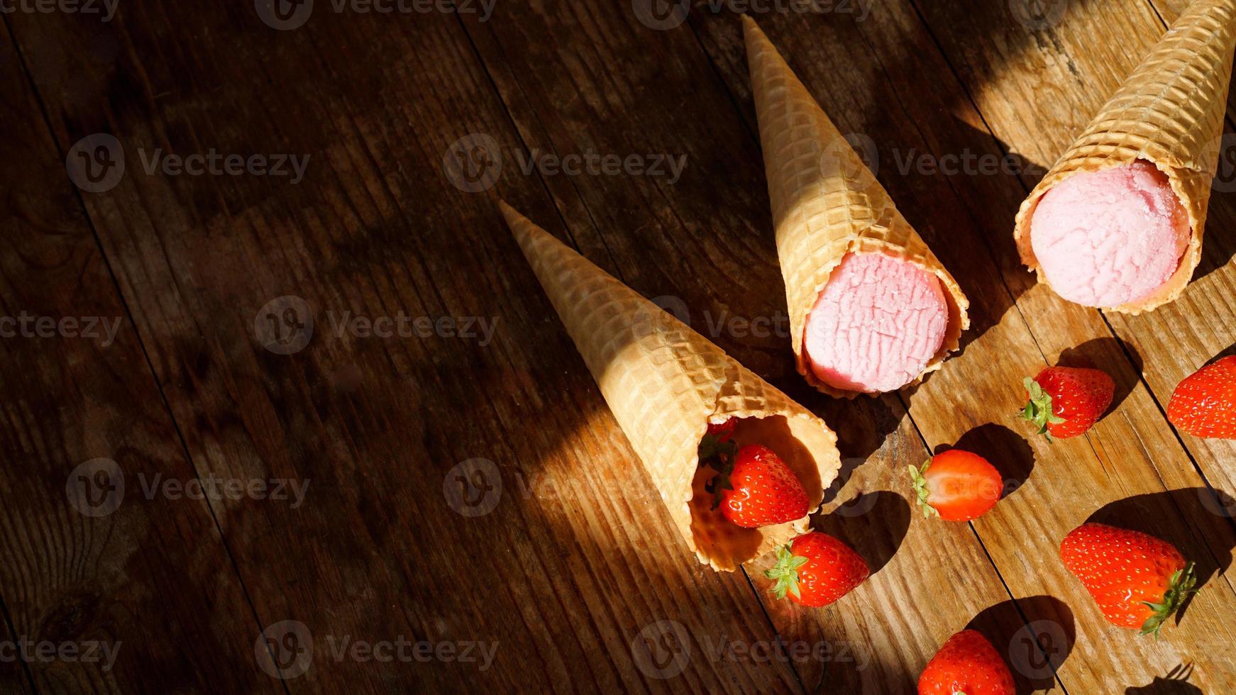 jordgubbsglass i en våffelkotte. röda bär och glassbollar foto