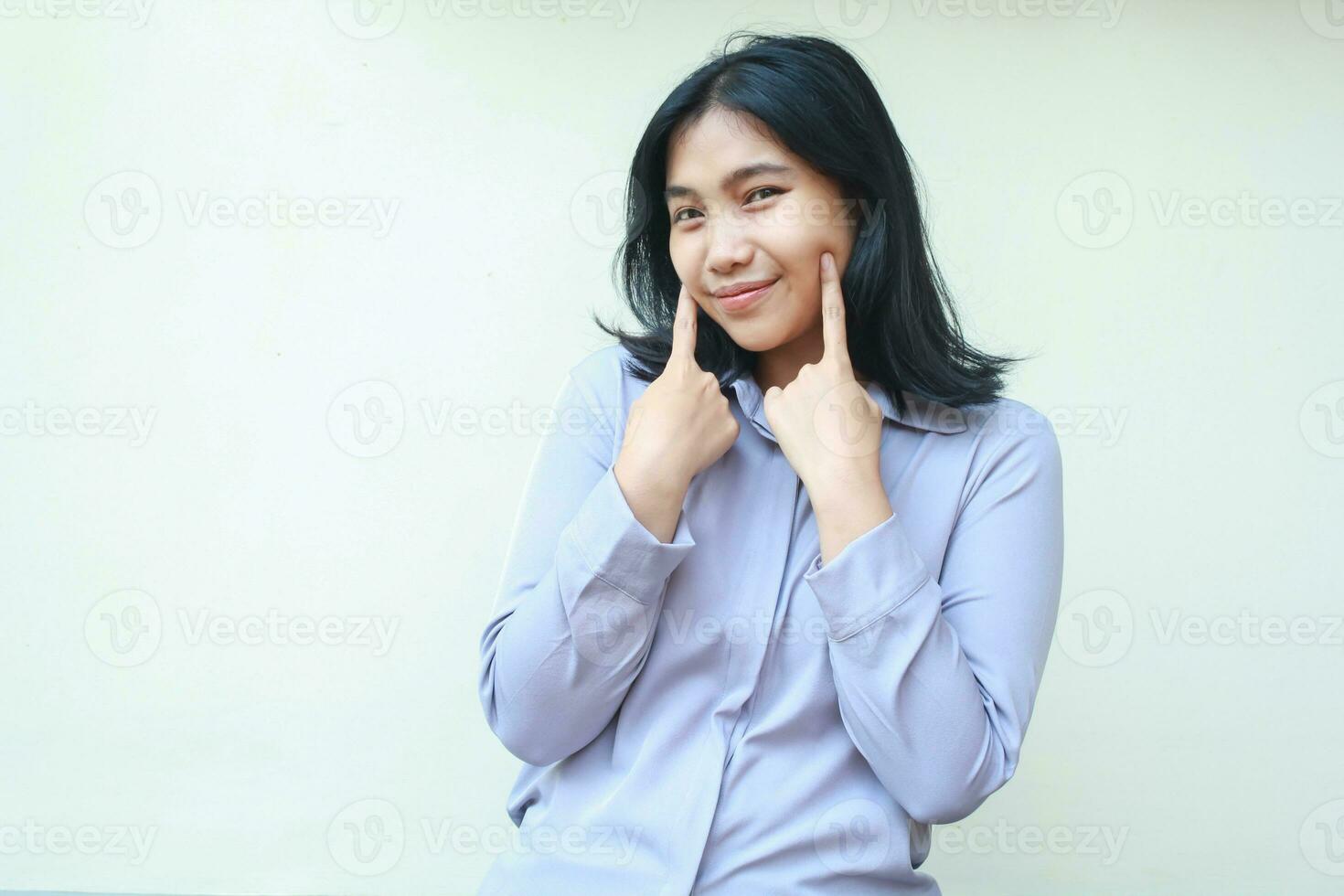 Lycklig tacksam asiatisk ung företag kvinna rörande henne kind med friska hud leende förtroende se kamera ha på sig formell skjorta isolerat på vit bakgrund, glad kvinna härlig anställa kontor arbetstagare foto