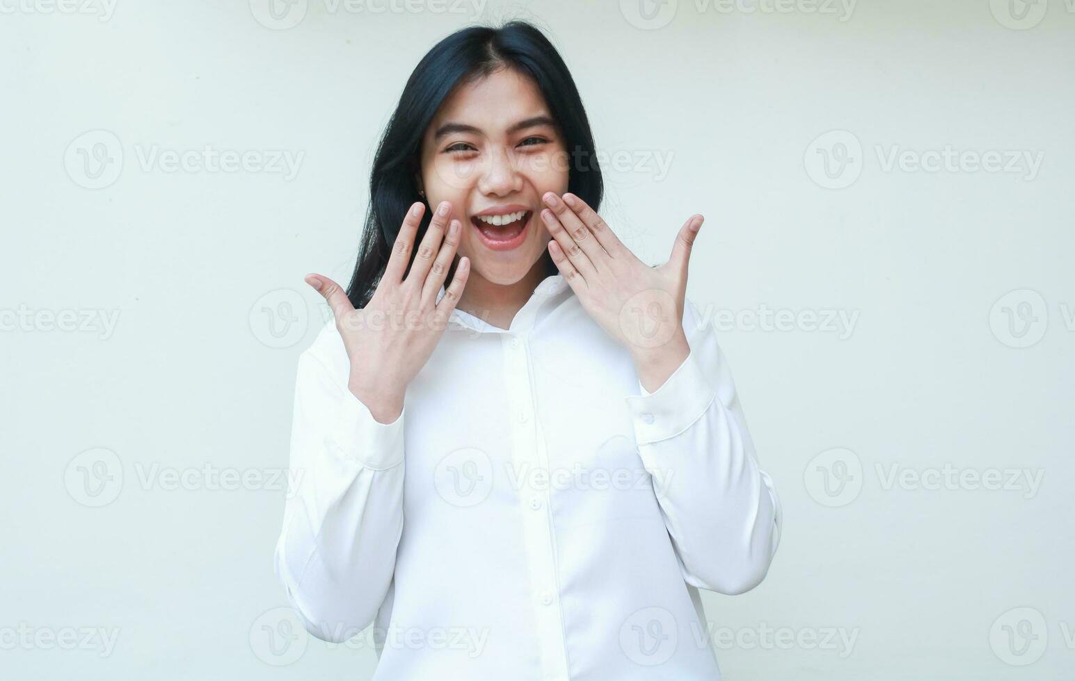överraskad asiatisk företag kvinna skrikande på kamera chockade med höjning händer beläggning ansikte bär vit skjorta formell kostym stående över isolerat bakgrund foto