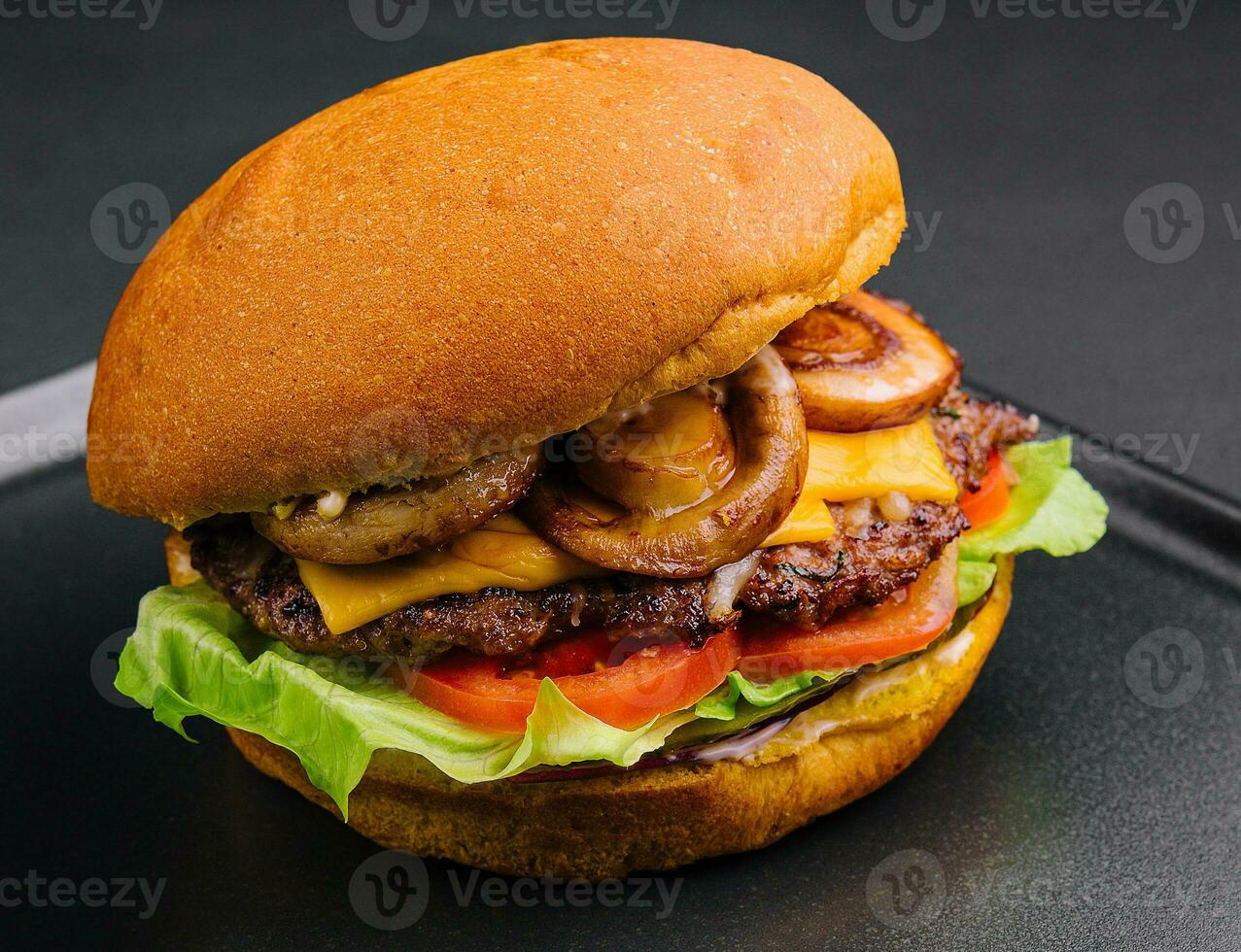 burger med svamp och kotlett på svart bricka foto