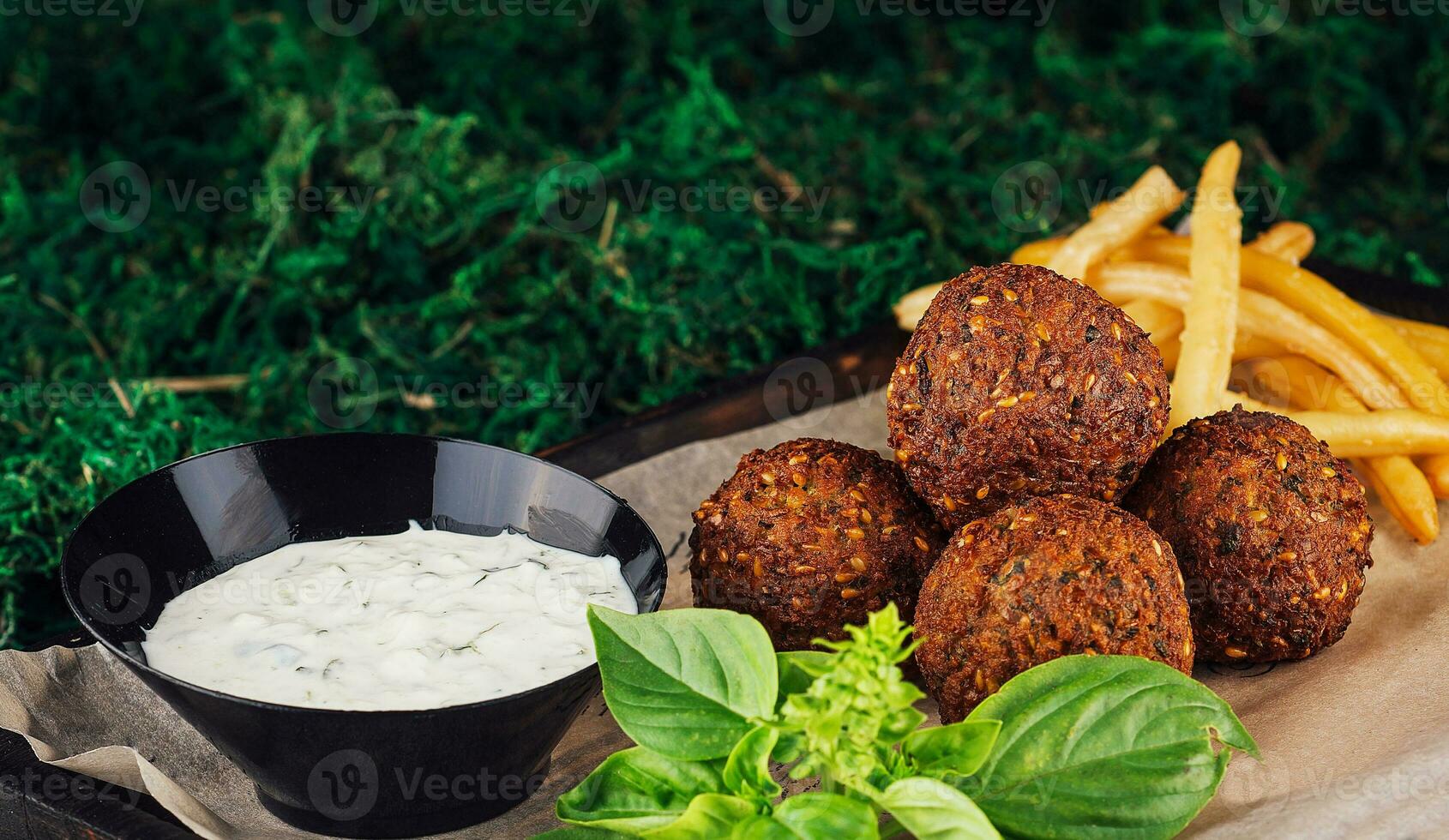 falafel med franska frites på trä- bricka foto