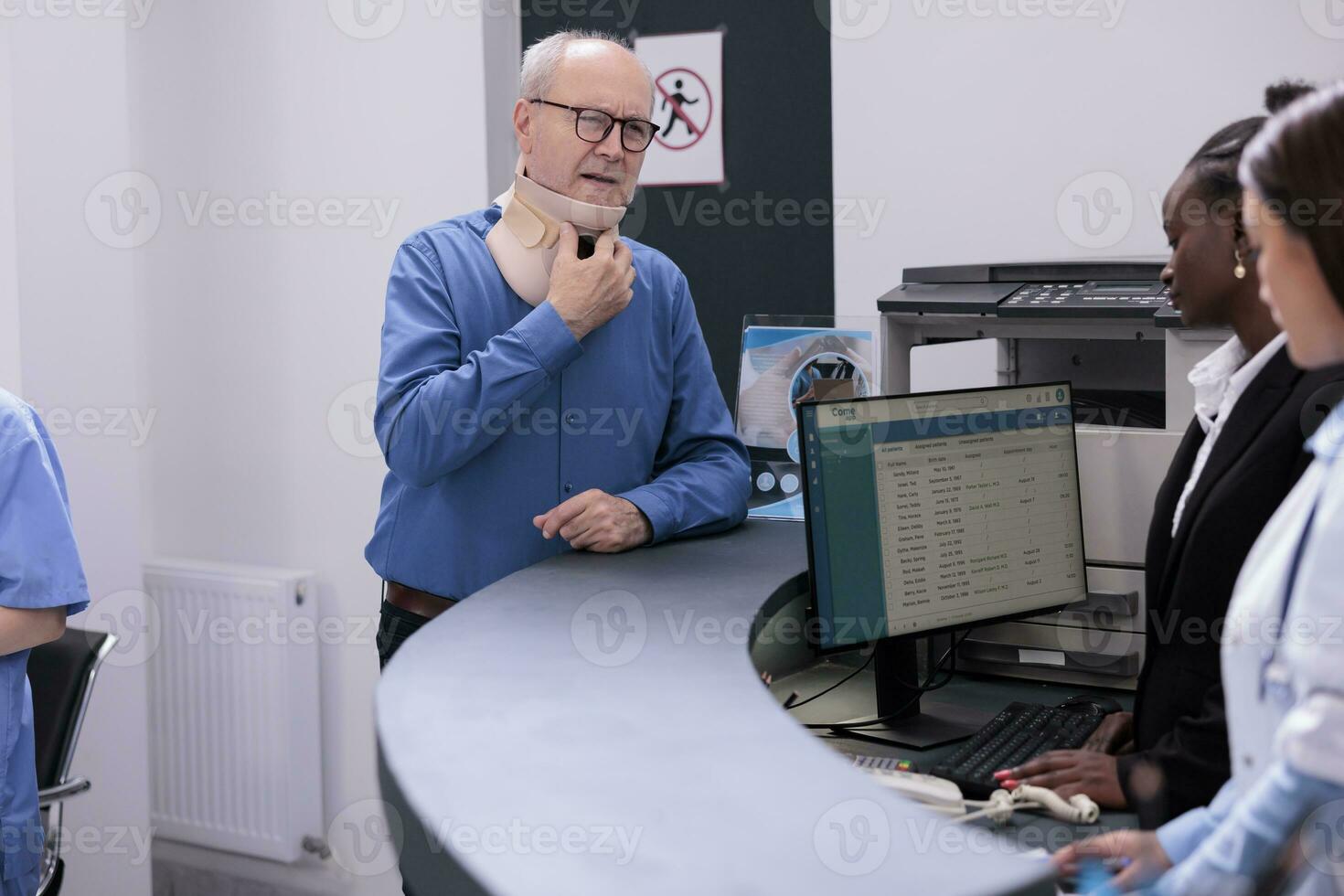 skadade äldre patient med cervical nacke krage stående på sjukhus registrering disken diskuterar handla om utnämning med receptionist. man med medicinsk spänna väntar till träffa med traumatolog. foto