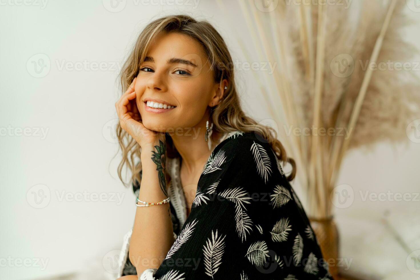 stänga upp porträtt av blond kvinna med perfekt leende i eleganta boho autfit. Framställ i lägre studio över vit bakgrund. foto