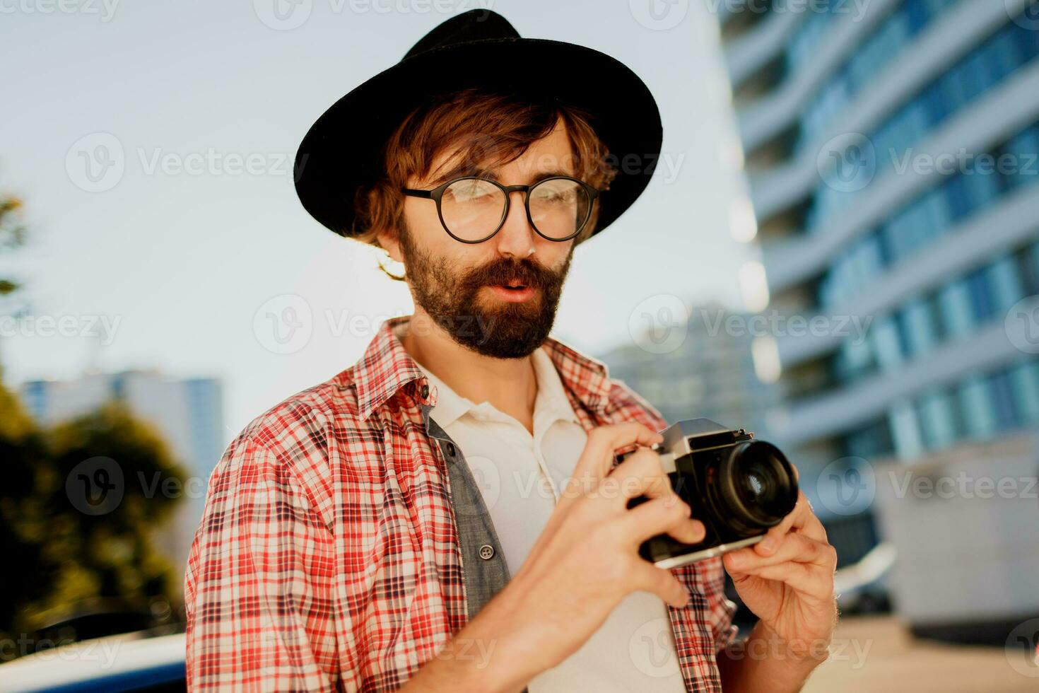 exits man med skägg med intressant använder sig av retro filma kamera , framställning foton. turist manen gående i stor modern stad. foto