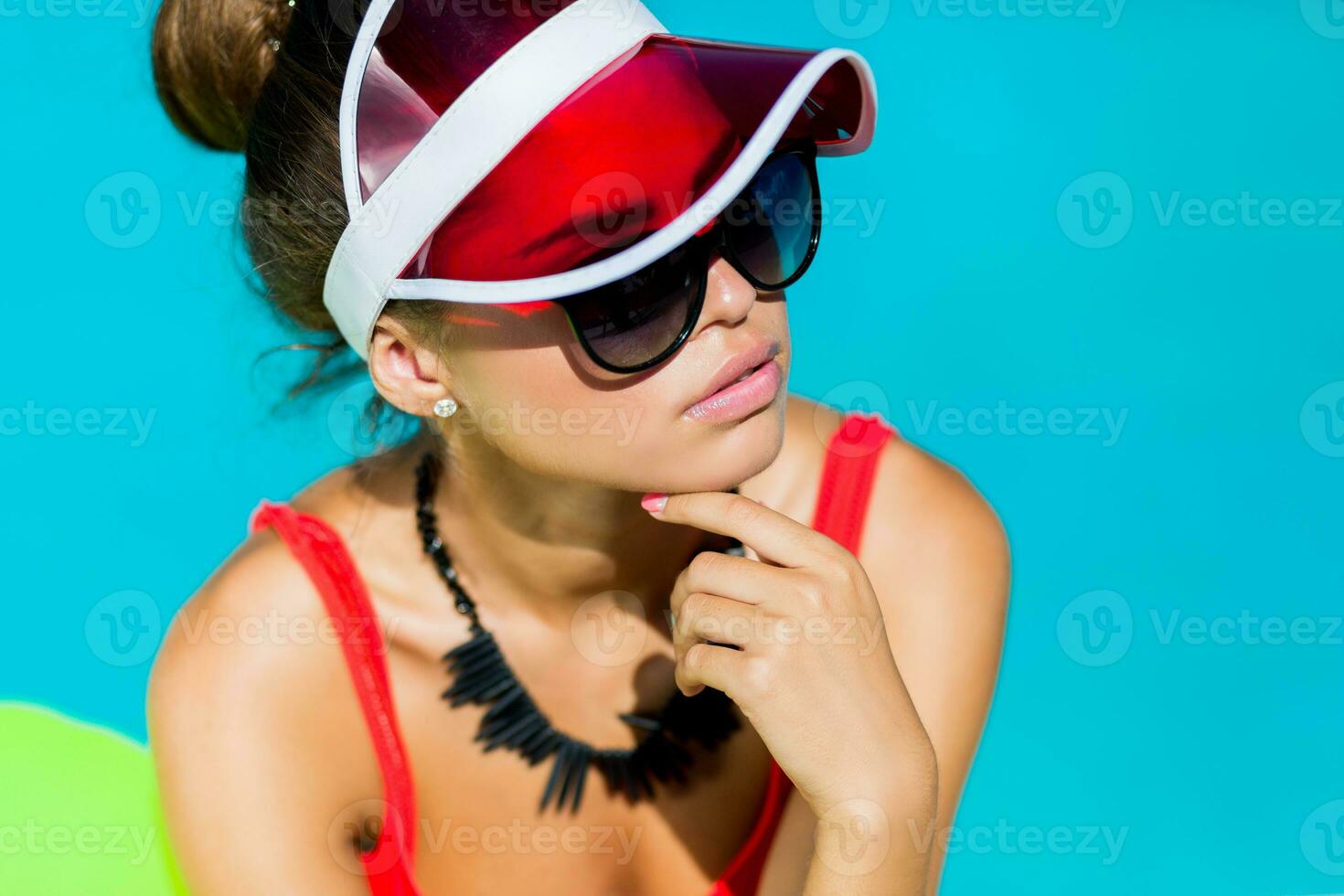 sexig solbränd kvinna i röd baddräkt har roligt och njuter sommar i Fantastisk stor simning slå samman. eleganta transparent keps. strand fest. foto