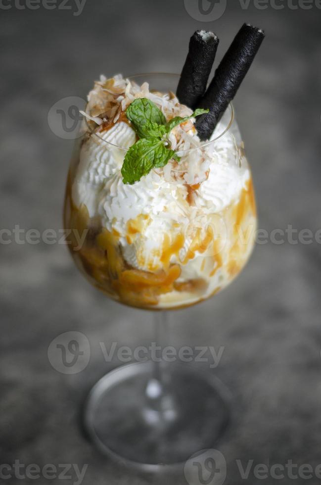 gourmet ekologisk kokos och karamell med glass sundae dessert i vinglas foto