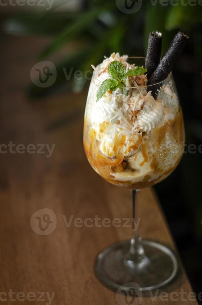 gourmet ekologisk kokos och karamell med glass sundae dessert i vinglas foto