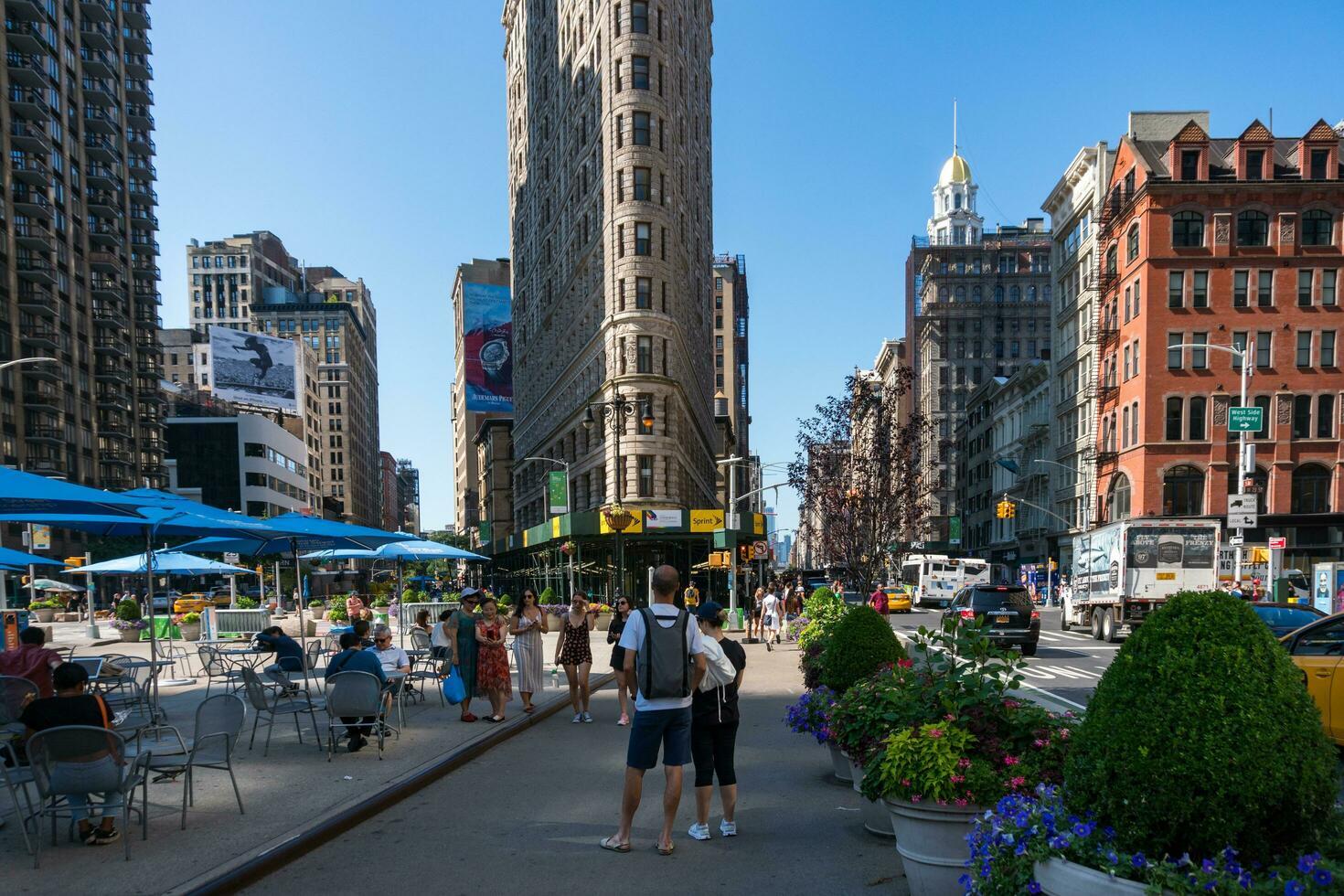 ny york stad, USA - augusti 9, 2019-människor promenader bland de känd skyskrapa kallad fatiron byggnad i manhattan under en solig dag foto