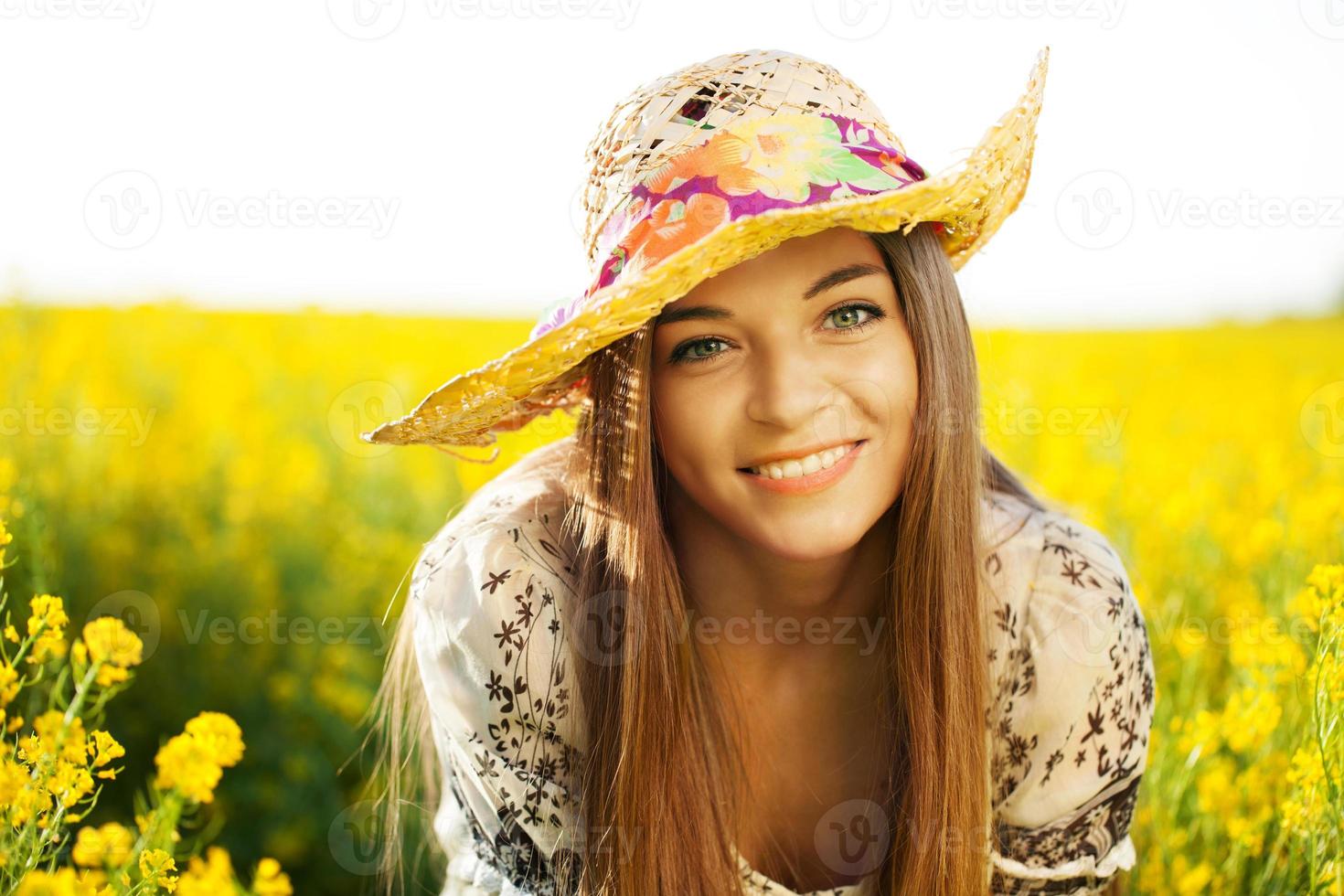 glad kvinna i en hatt av vildblommor foto