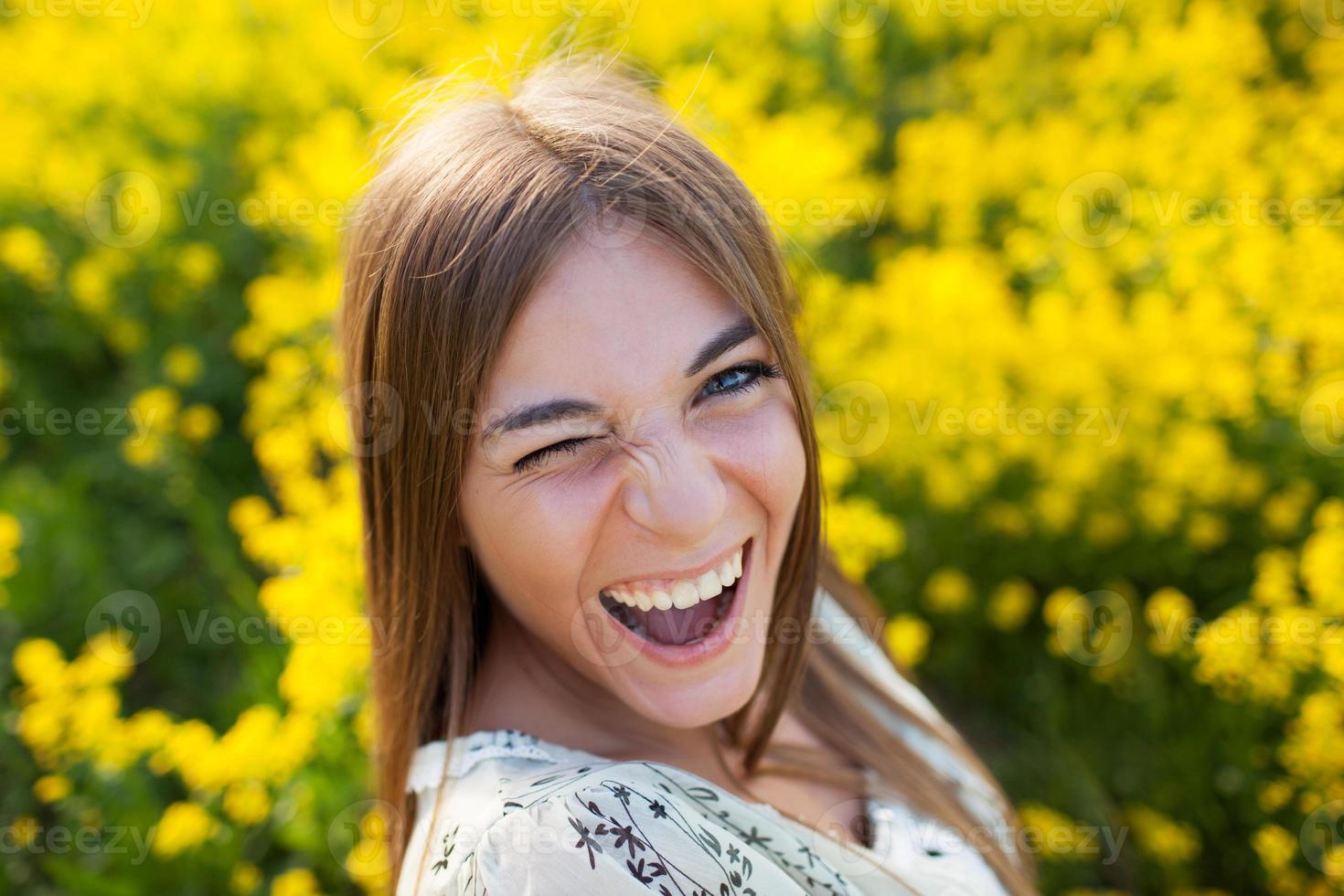 lekfull ung kvinna bland gula blommor foto