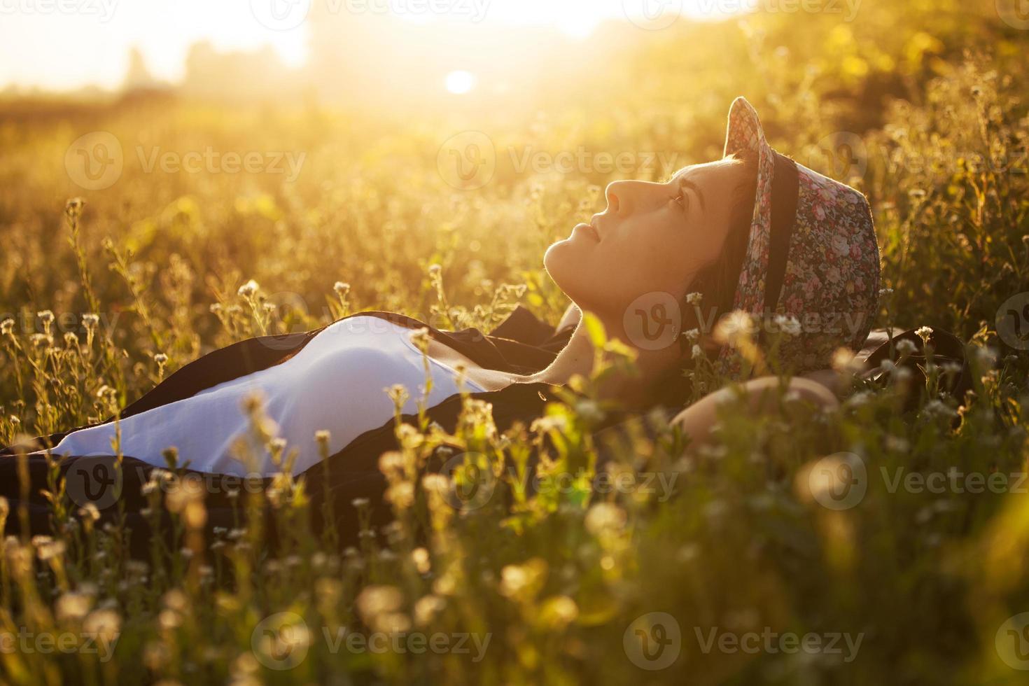 glad tjej ligger bland de vilda blommorna foto