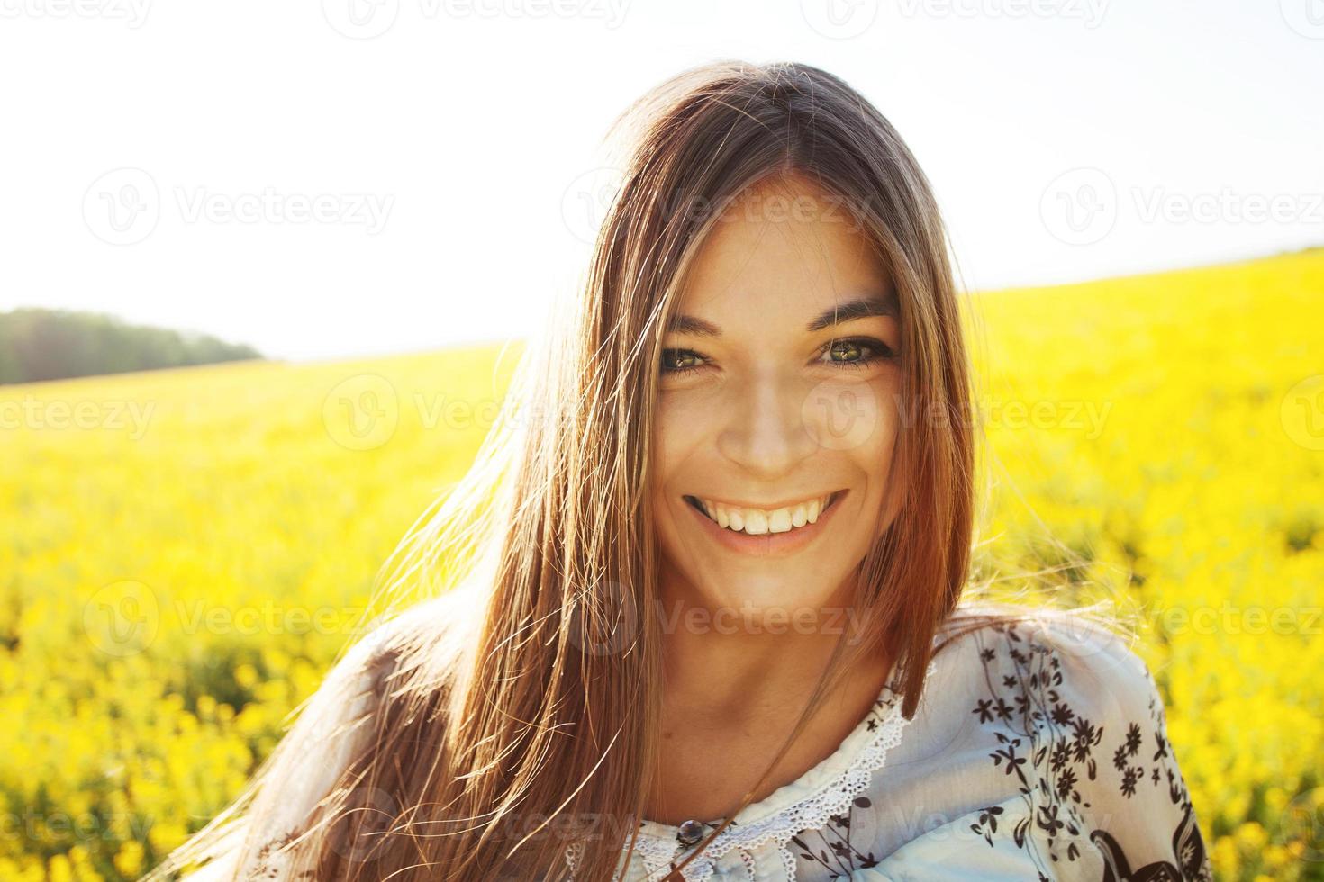 glad tjej i ett fält av gula blommor foto