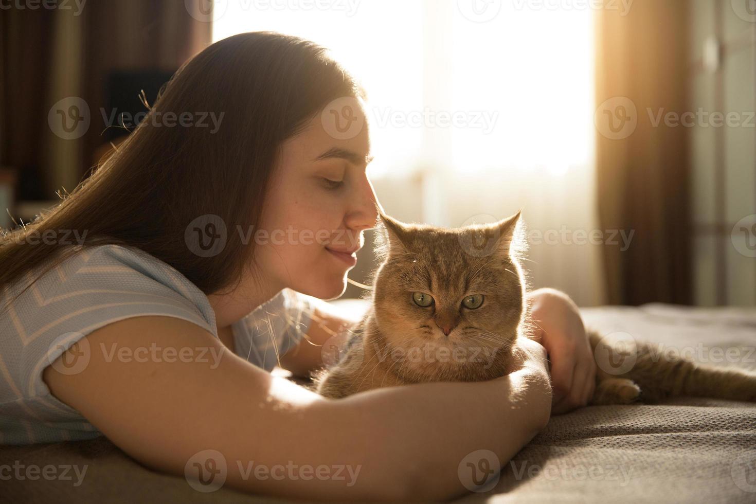 flicka som kramar sin älskade röda katt. fokusera på katten foto