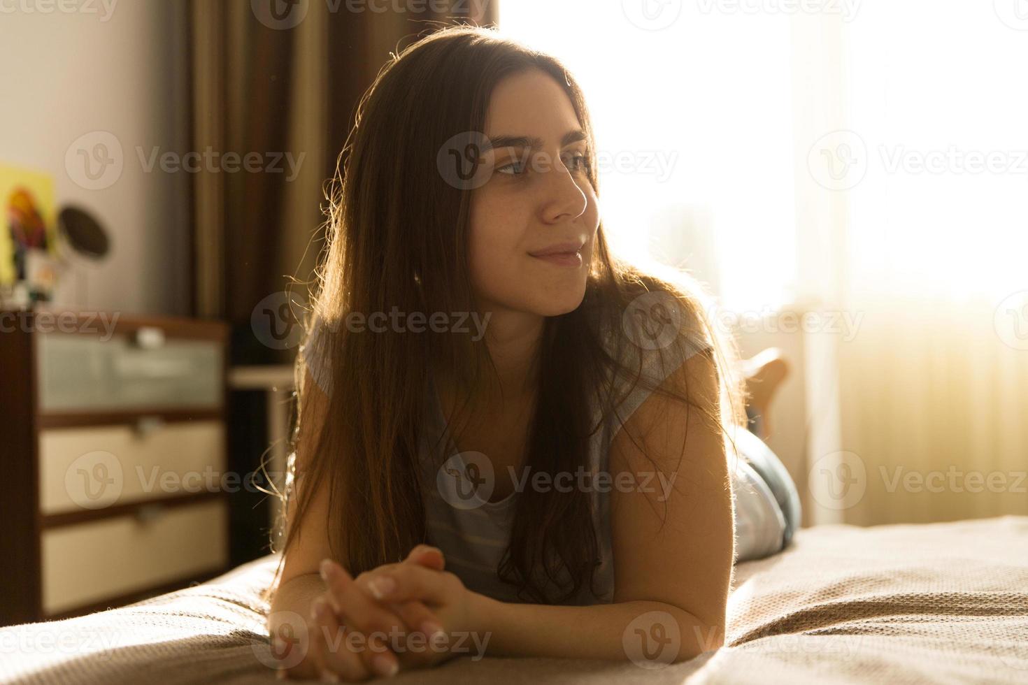ung kvinna som ligger hemma på sängen foto