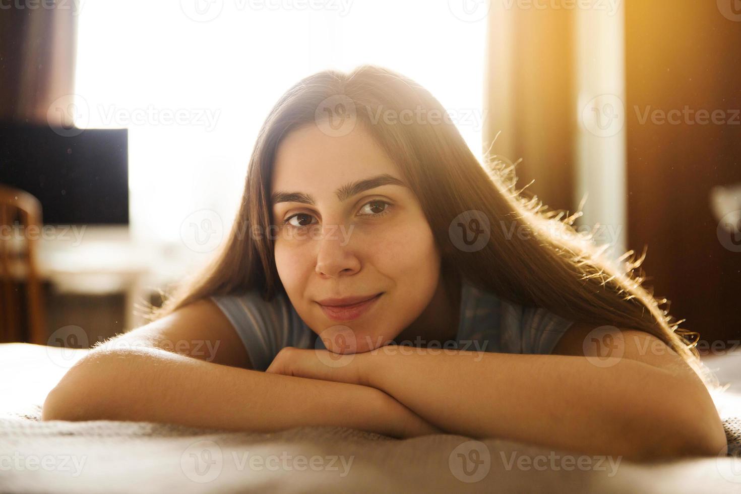 flicka som ligger hemma på sängen foto
