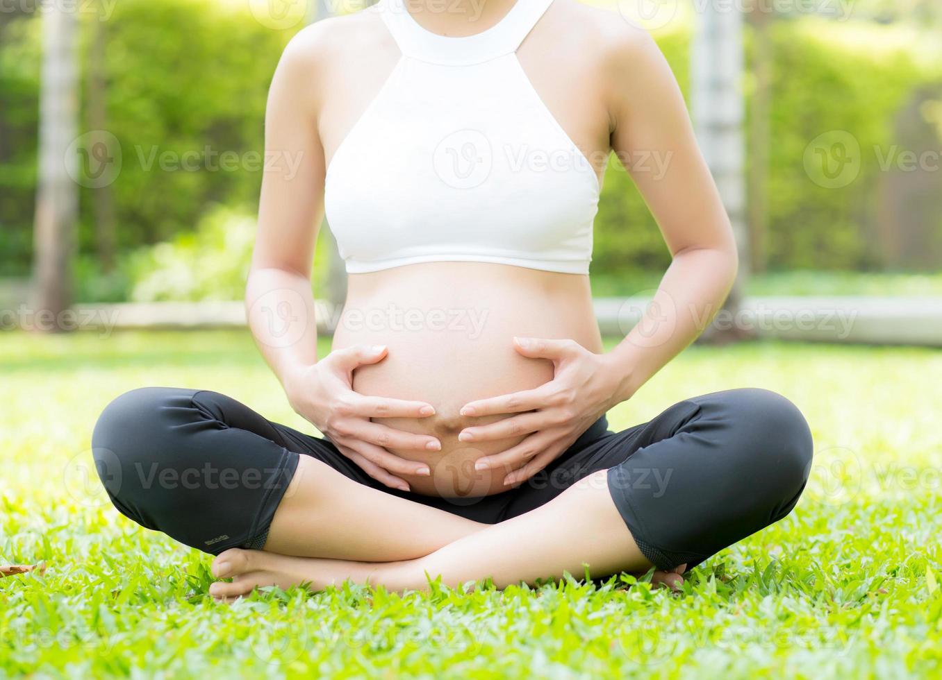 gravid asiatisk ung kvinna koppla av i parken. foto