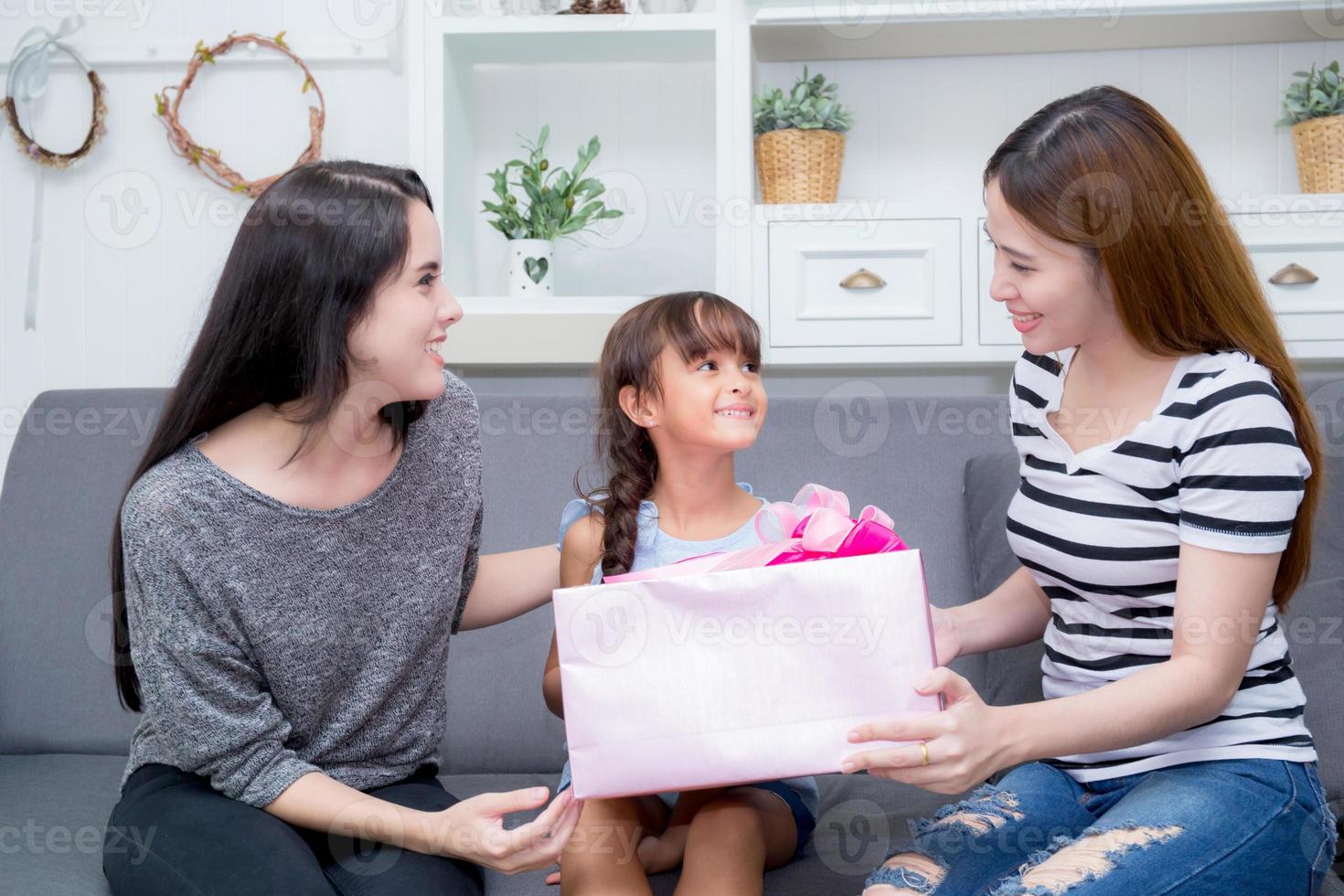 lycklig familj, mamma och dotter ger presentask med dotter. foto