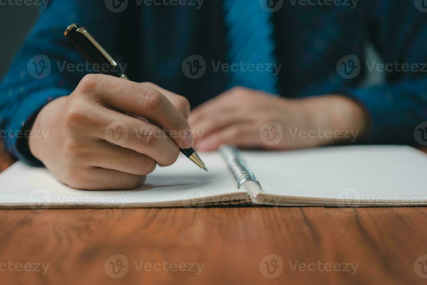 hand innehav penna checklista papper arbete på skrivbord. signering information kontrakt och avtal. kryssruta Rapportera frågor kund tjänster. skriva utbildning och inlärning läxa. foto