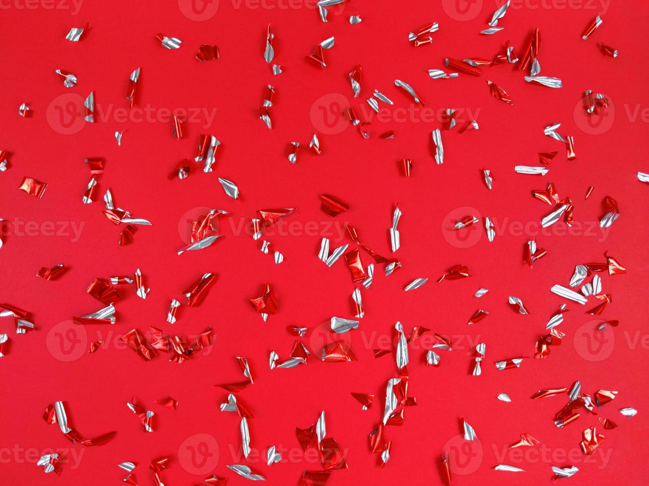 konfetti folie bitar på röd bakgrund. abstrakt festlig bakgrund. foto