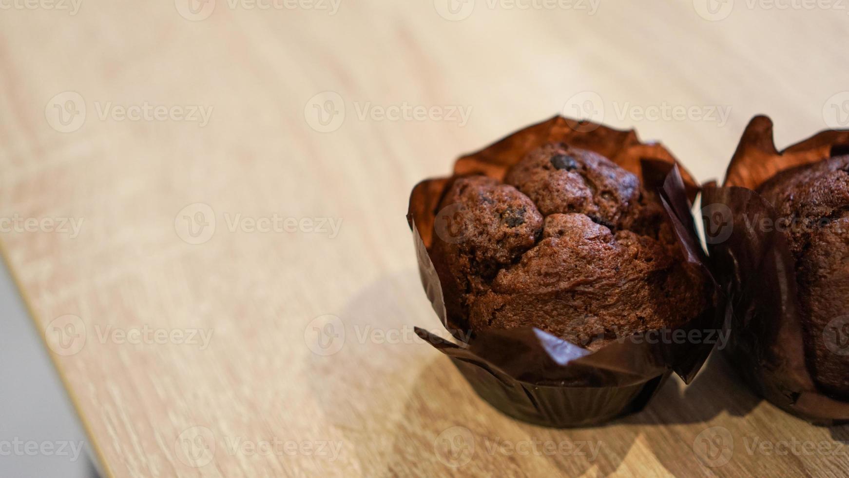 två chokladmuffins på träbord foto