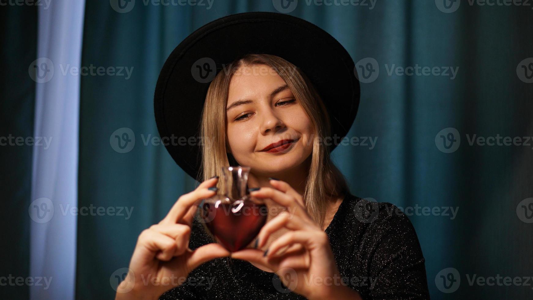 beskuren bild av kvinna som håller hjärtformad glasburk med kärleksdryck foto