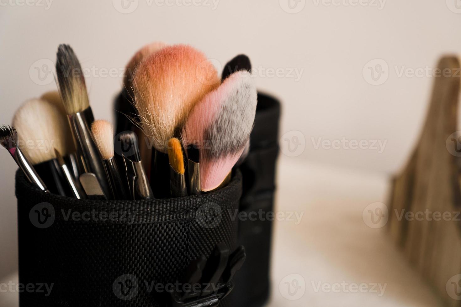 sminkborstar i ett makeupartistfodral på suddig bakgrund foto