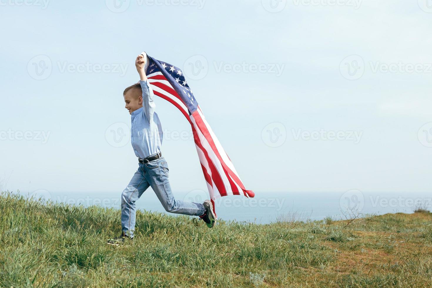 en liten pojke springer med USA: s flagga foto