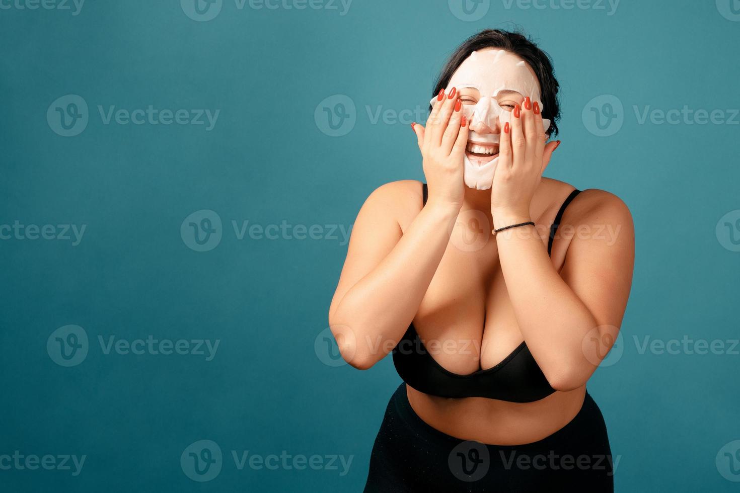 glad plus size tjej gör full split med hudvårdsmask foto