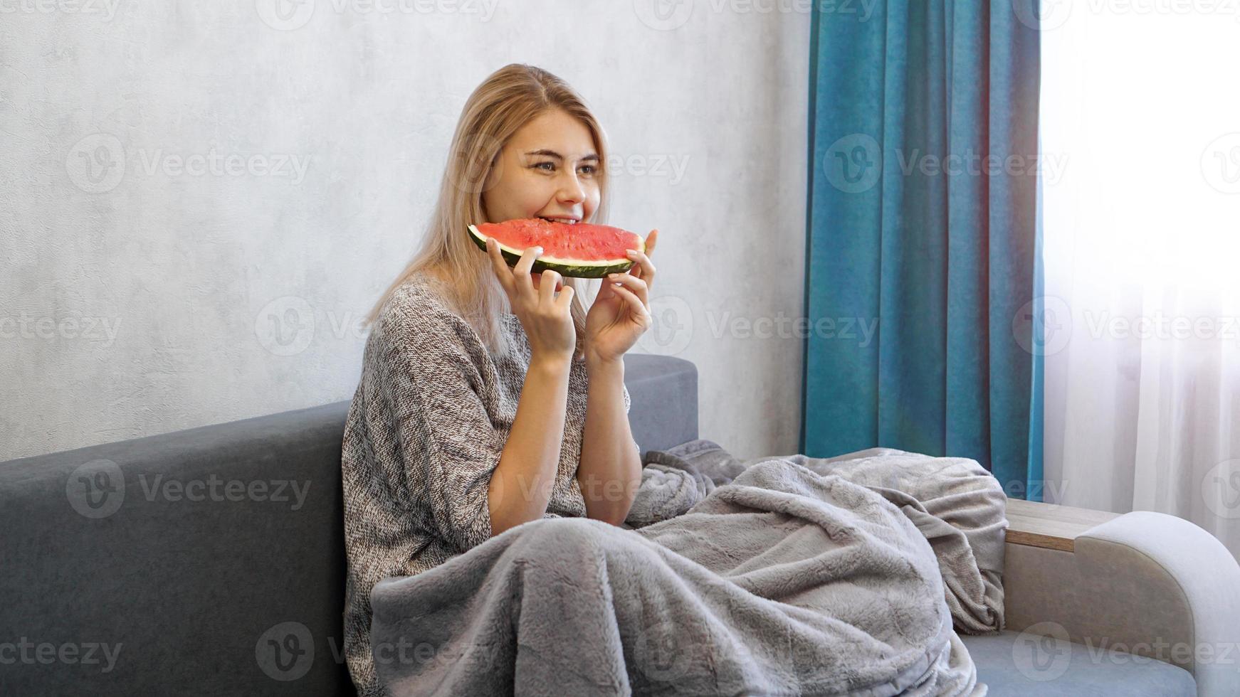 ung attraktiv kvinna som äter vattenmelon. kvinna hemma foto